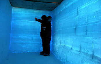 Photo of a researcher examining layers in a snow pit.