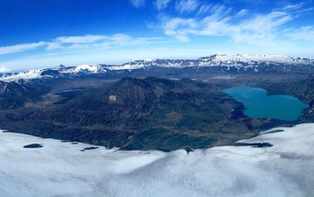 Caldera of Okmok Volcano in the Aleutians, with Vsevidof and Recheshnoi volcanoes in the distance.