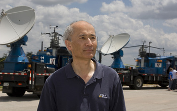 Photo of Roger Wakimoto with 2 satellite dish trucks in the background