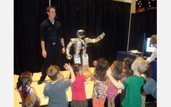 Jaemi, a humanoid robot (HUBO), and his child fan base wave goodbye at end of visit to museum