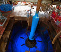 A recovery tool for seafloor equipment rises through the ship's moonpool.