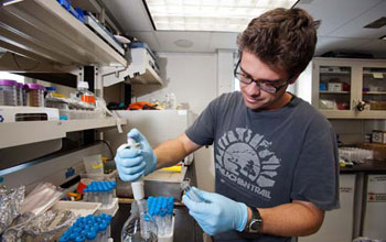 microbiologist Joe Russell examining samples in the lab onboard the JOIDES Resolution.