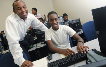 Professor with students working on a computer