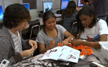 three students building a mini robot