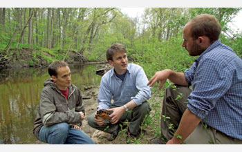 TurtleNet research participants examine a wood turtle by the Deerfield River in western Mass.