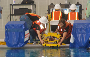 Photo of two Long Beach City College ROV Team members launching the ROV in the pool.
