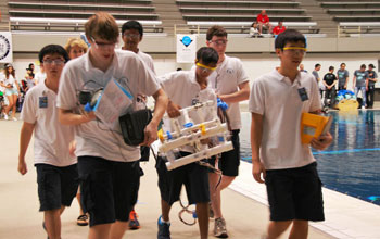 Students walking back with their remote underwater vehicles