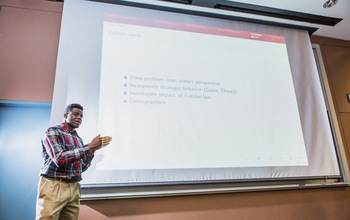 student in front of slide presentation