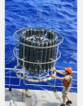 Photo showing marine scientists obtaining ocean water samples aboard a research vessel.