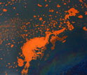 Photo of oil slick at the sea's surface containing orange-colored older oil and fresher oil sheen.