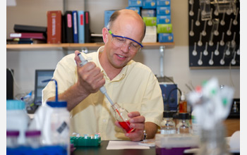 Photo of Nicholas Hud extracting a study sample in his laboratory.
