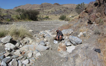 Photo of scientist Paul Bierman sieving a river bed to extract the medium sand fraction.