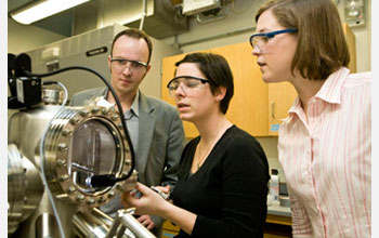 Photo of Charles Sykes and two graduate students using a scanning tunneling microscope.