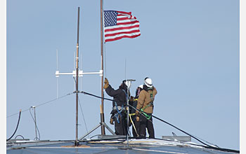 Photo of crew lowering the U.S. flag from the old South Pole Station Dome