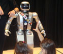 Photo of children reaching out for Jaemi Hubo, an NSF-funded international robotics collaborative.