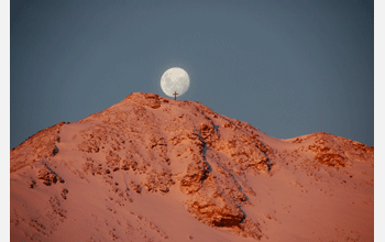 A full moon behind the cross on Observation Hill at McMurdo Station, Ross Island, Antarctica