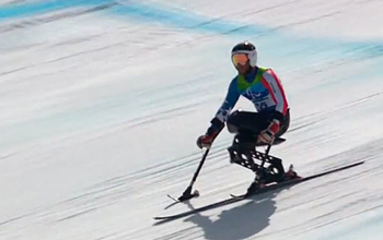 man skiing downhill on a mono-ski