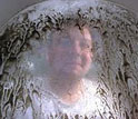 Photo of a researcher behind a screen with oyster larvae.