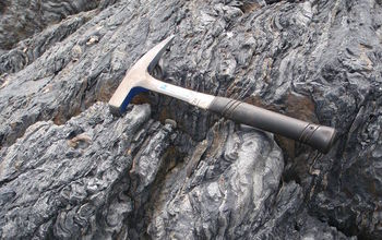 Sedimentary rocks with hammer lying on top.