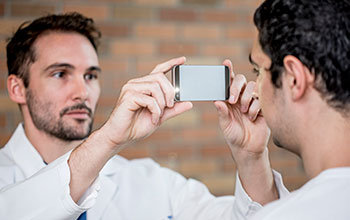 Man holding a smartphone in front of another man