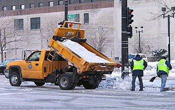 workers spreading salt from a salt truck