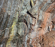 A close-up shows the rocks that make up a wall of the underground mine.