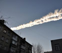 Sky showing a meteor as it streaked by buildings in Russia.