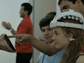 Girl with EEG cap looking at a device surrounded by people