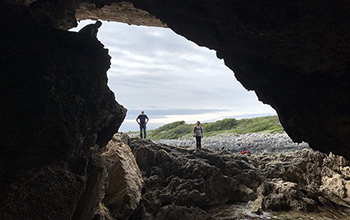 research team members standing at the entrance of a cave
