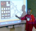A middle school student pointing to a screen projection describes a mathematical image.