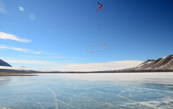 Photo of a helicopter carrying SkyTEM mapping technology over Lake Fryxell in Antarctica.