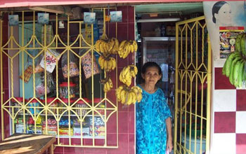 Photo of a woman standing at the door of her store.