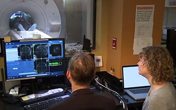 Two researchers observing open fMRI