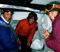 Photo of Noah Molotch, Danielle Perot and Ty Atkins studying snow properties from inside a snow pit.