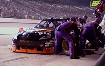 Crew changing tires on a race car in the pit