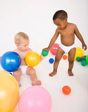 two young children playing with balls.