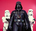 Photo of Darth Vader with stormtroopers holding blasters.