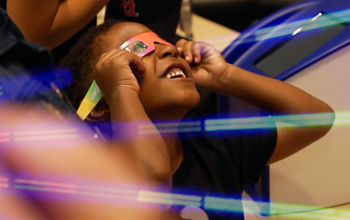 child wearing protective glasses looking at light