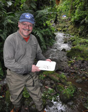 Photo of scientist LeRoy Poff sampling aquatic insects along a vine-choked stream in Ecuador.