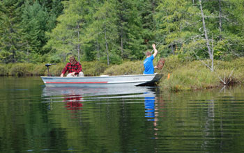 Photo of Tim Cline on the left and Lee Zinn on the right in a boat sampling minnows.