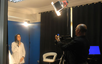 A videographer and a Moroccan Sign Language interpreter record signs in a studio