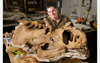 Photo of Scott Sampson with the fossil of the species Kosmoceratops richardsoni.