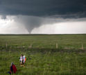 Photo of researchers studying a tornado from a safe distance away.