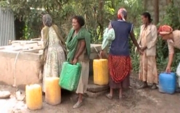 women filling jugs with water