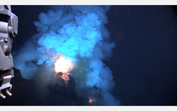 Photo of  a bright flash of hot magma blown up into the water before settling back to the seafloor.
