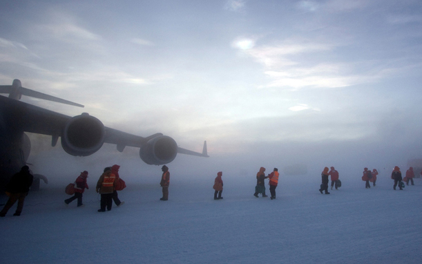 Passengers make their way from an Air Force C-17 air transport at Pegasus Airfield, Antarctica.