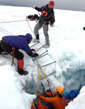 Three scientist perform a crevasse search-and-rescue drill
