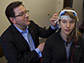 a professor adjusts electrodes on the scalp of a study participant