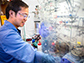 Niankai Fu working in a vented hood conducts electrochemical research
