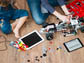 kids sitting on the floor with multiple electronics